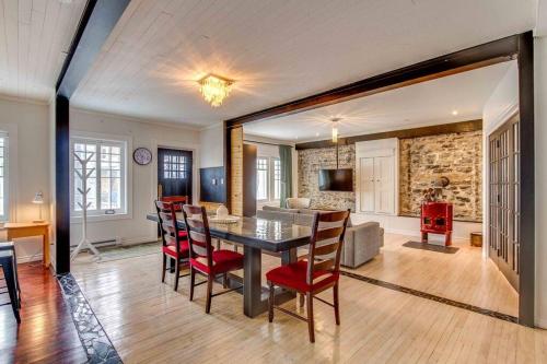a dining room and living room with a table and chairs at La Maison bleue des Artistes in Quebec City