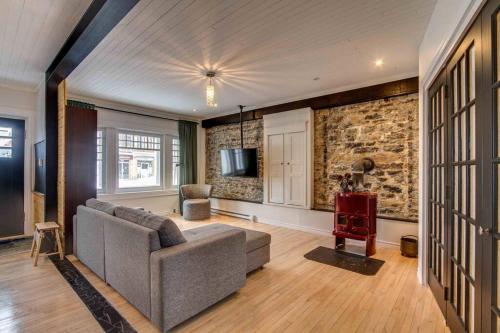 a living room with a couch and a tv at La Maison bleue des Artistes in Quebec City