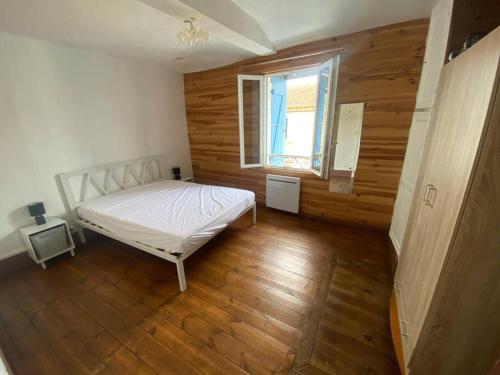 - une chambre avec un lit blanc et une fenêtre dans l'établissement Maison de rue centre ville, à Mirande