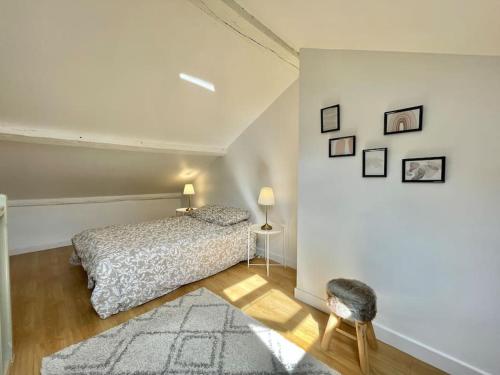 a bedroom with a bed and a white wall at Duplex de caractère 50 m² in Moulins