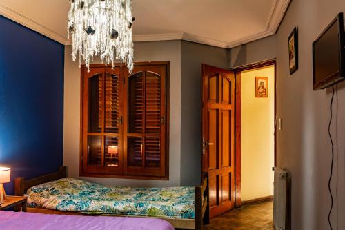 1 dormitorio con cama y lámpara de araña en Elisa Posada Hotel en Córdoba
