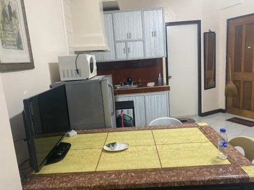 eine kleine Küche mit einem Tisch und einer Mikrowelle in der Unterkunft Baguio Breeze Condo2 in Baguio City