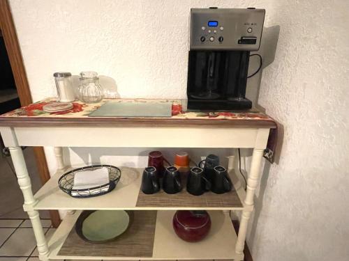 a table with a coffee maker on top of it at Cozy house centrally located close to everything in NWA in Springdale