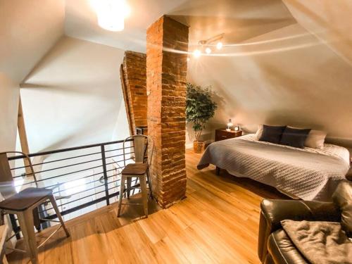 um quarto com uma cama e um pilar de tijolos em Custom Dream home, loft/porch, trendy neighborhood em Colorado Springs
