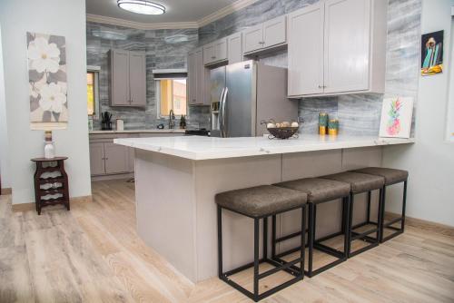 a kitchen with a large counter with stools at MARIBELLA@CRYSTAL COVE OCHO RIOS in Stanmore Grove