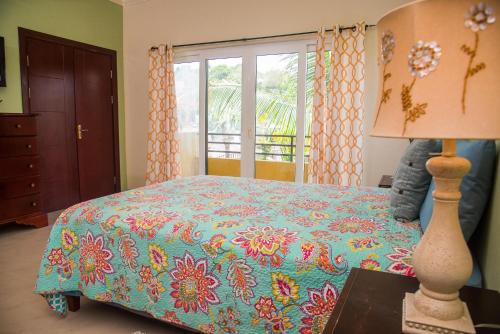 1 dormitorio con 1 cama con un edredón colorido en MARIBELLA@CRYSTAL COVE OCHO RIOS en Stanmore Grove