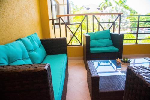 a balcony with two chairs and a couch and a table at MARIBELLA@CRYSTAL COVE OCHO RIOS in Stanmore Grove