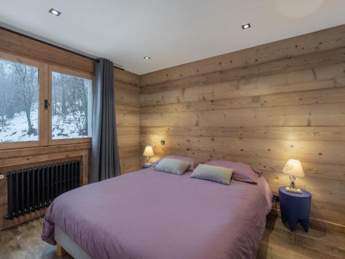 a bedroom with a bed and a wooden wall at CHALET " JEANE " proche centre in Megève