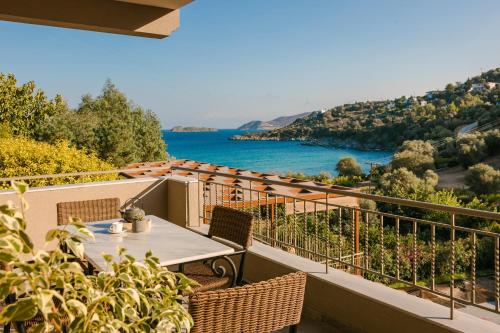 a balcony with a table and a view of the water at Paramithenio Village Beach Resort & Spa in Áyioi Apóstoloi