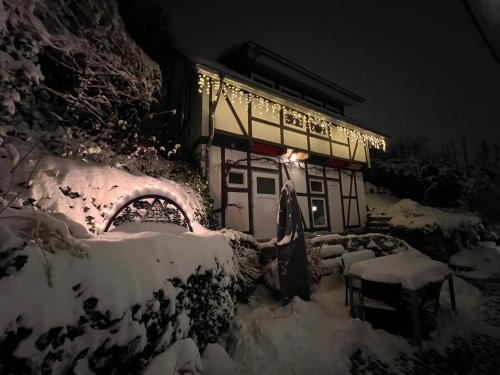 a building covered in snow at night with lights at Harz im Glück - Fachwerkhaus für zwei in Wernigerode in Wernigerode
