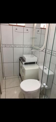 Un baño con un inodoro blanco y un espejo. en Casa1, en Itapema