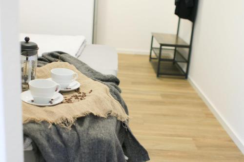 - un salon avec 2 tasses à café et une couverture dans l'établissement Baumhof55-2, à Marktheidenfeld