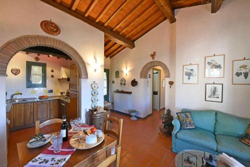 a living room with a blue couch and a kitchen at Bacco in Gaiole in Chianti