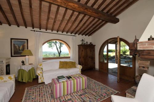 ein Wohnzimmer mit einem Bett und einem großen Fenster in der Unterkunft Ginestra in Castellina in Chianti