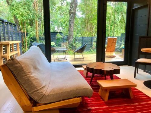 a living room with a couch and tables on a rug at Calma Cabins in Puerto Clocker
