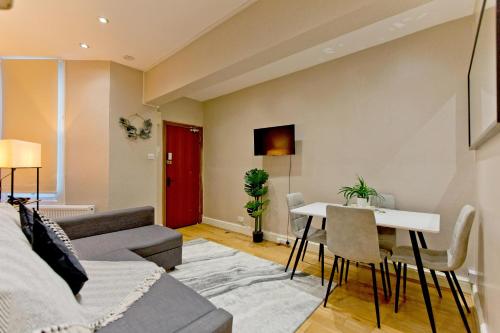 a living room with a couch and a table at Imperial Earls Court Apartments in London