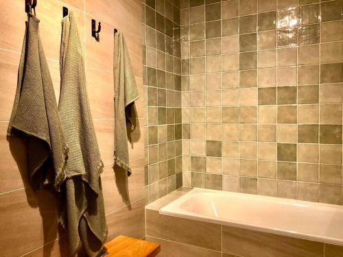 a bathroom with a tub and a towel rack at Calma Cabins in Puerto Clocker
