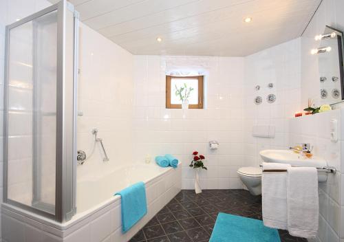 een witte badkamer met een bad en een toilet bij Ferienwohnung Jochum-Pfeiffer in Riezlern
