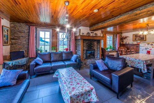 a living room with couches and a fireplace at A Tchapè Mèlé in Gouvy