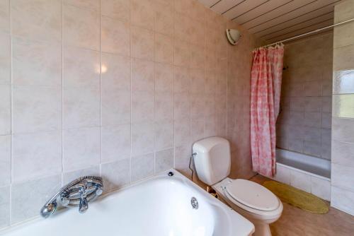 a bathroom with a toilet and a bath tub at A Tchapè Mèlé in Gouvy