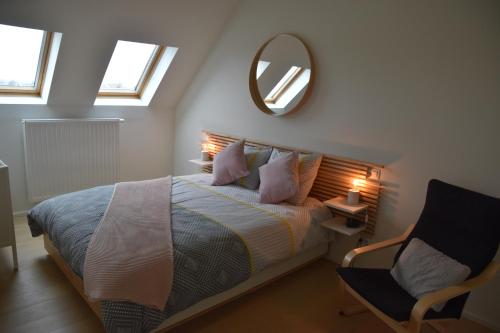 um quarto com uma cama com um espelho e uma cadeira em Riposo em Poperinge