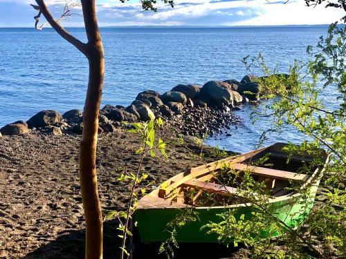 a boat sitting on a beach next to the water at Calma Cabins in Puerto Clocker