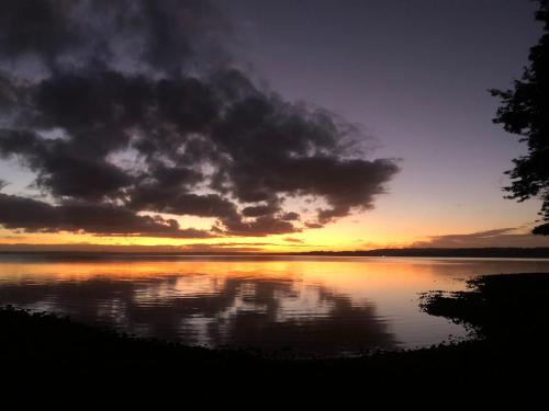 a sunset over a large body of water at Calma Cabins in Puerto Clocker