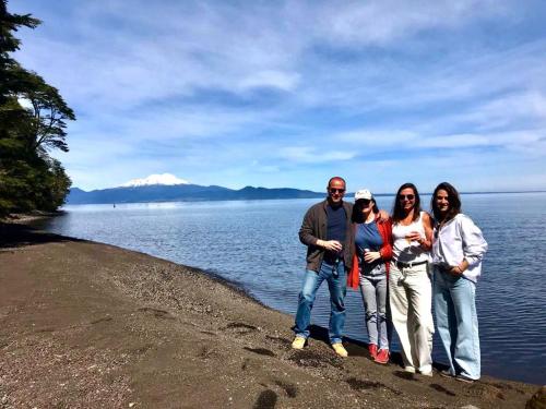 a group of people standing on the shore of a lake at Calma Cabins in Puerto Clocker