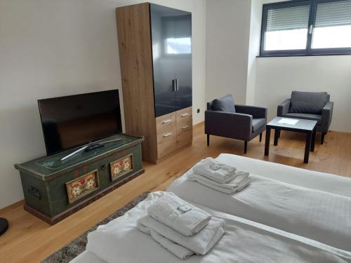 a bedroom with a bed and a flat screen tv at Pension Sunnseitn - Gasthof - Café - Weinkeller in Haslach an der Mühl