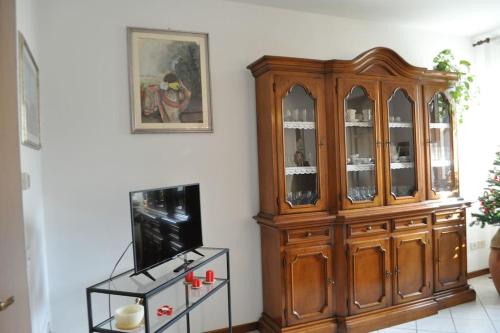 einen großen Holzschrank in einem Wohnzimmer mit einem TV in der Unterkunft La Casa di Tommy in Monsagrati