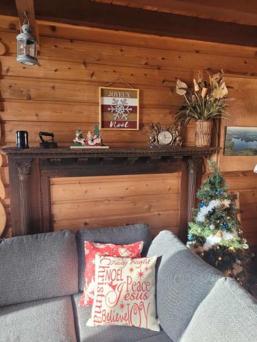 a living room with a couch and a christmas tree at Le petit chalet sur le lac in Sainte-Marguerite
