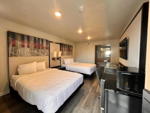 Habitación de hotel con 2 camas y TV de pantalla plana. en GO2 Inn & Suites by Relianse en El Paso