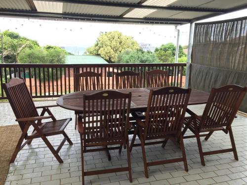 a wooden table and four chairs on a patio at Bella@Jbay in Jeffreys Bay