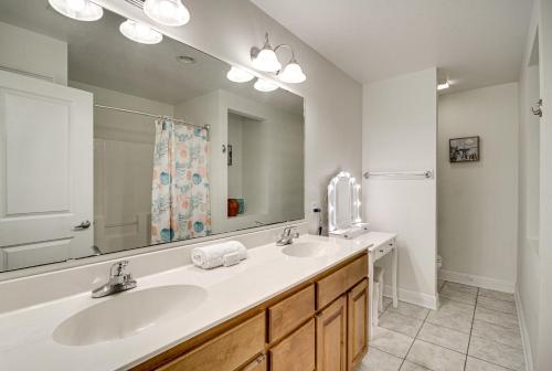 a bathroom with two sinks and a large mirror at Ideally Located Gulfport Condo Less Than 1 Mi to Beach! in Gulfport