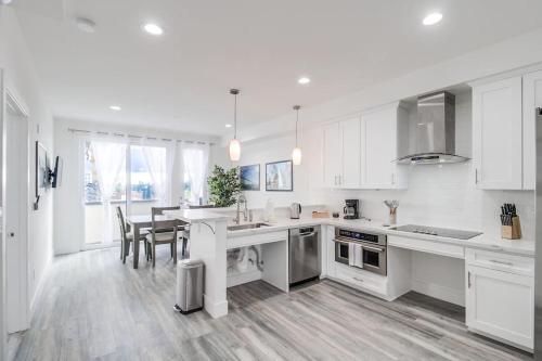 a kitchen with white cabinets and a table and chairs at Park Blvd 301 - Modern - Urban Oasis - SPA in San Diego