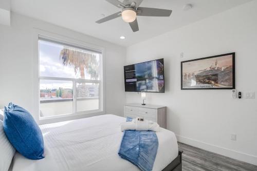 a bedroom with a white bed with a ceiling fan at Park Blvd 301 - Modern - Urban Oasis - SPA in San Diego