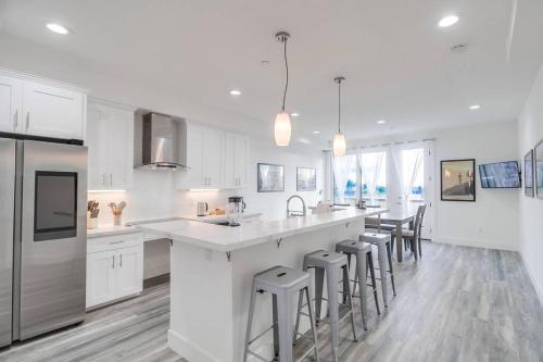 a white kitchen with a large island with bar stools at Park Blvd Paradise 302 ADA compliant with a Spa in San Diego