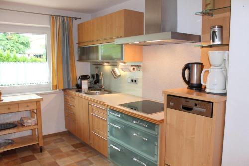 a kitchen with wooden cabinets and a counter top at Ferienwohnung Stuibenfall in Jerzens