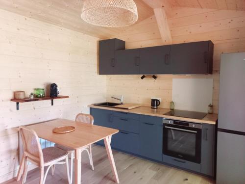 eine Küche mit einem Holztisch und einem Kühlschrank in der Unterkunft maisonette et spa bois in La Bégude-de-Mazenc
