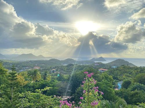 a view of the sun in the sky with trees at Hummingbird Villa - Tropical 3 bedroom Villa with Panoramic Views home in Cap Estate