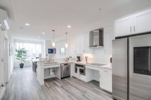 a kitchen with white cabinets and stainless steel appliances at Park Blvd Paradise 303 king bed With a private Spa in San Diego