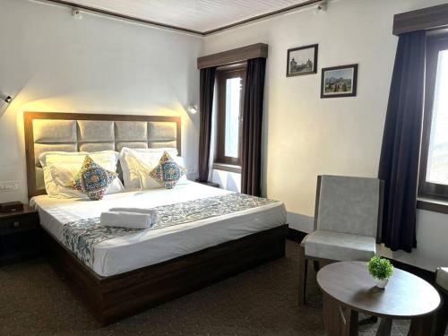 a bedroom with a large bed and a chair at Feather Stays - 4 BHK Apartment in a Villa in Srinagar