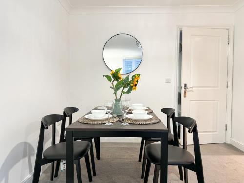 a dining room table with a mirror and chairs at Luxury 2 Bedroom City Centre Apartment - Secure Parking - Amazing location! in Canterbury