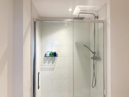 a shower with a glass door in a bathroom at Luxury 2 Bedroom City Centre Apartment - Secure Parking - Amazing location! in Canterbury