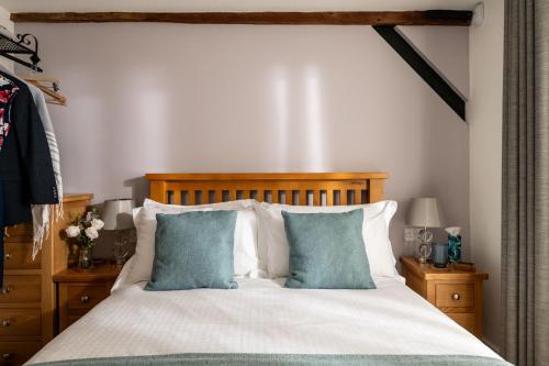a bedroom with a bed with two blue pillows at The Cart House in Southampton