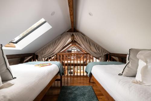 a attic room with two beds and a window at The Cart House in Southampton