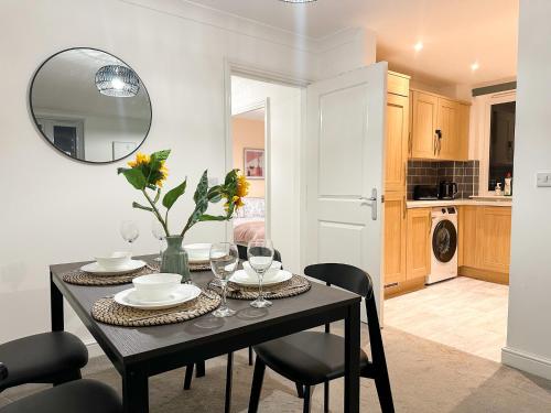 a dining room with a table and a mirror at Luxury 2 Bedroom City Centre Apartment - Secure Parking - Amazing location! in Canterbury