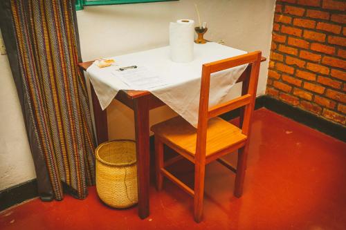 a small table with a chair and a paper on it at Room in Guest room - Isange Paradise Resort in Ruhengeri
