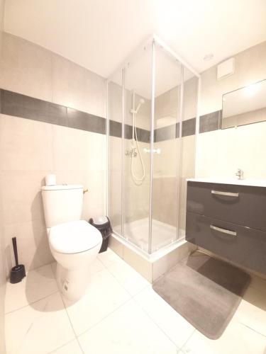 une salle de bain avec toilettes et douche en verre dans l'établissement Gîte Narbonnais avec chambre- proche des plages-Jardin-Terrasse-Parking, à Narbonne
