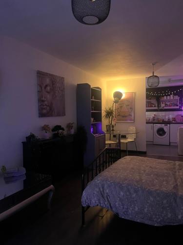 1 dormitorio con 1 cama y cocina con luces moradas en THE ONE WITH THE PEACEFUL VIBES, en Londres